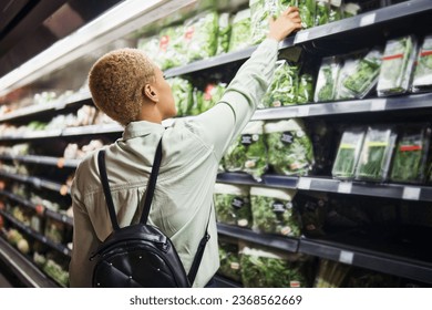 Vegetables, back and woman grocery shopping at shelf in store, retail and supermarket. Groceries, healthy food and customer in shop for choice of product, sales deal and discount on organic lettuce. - Powered by Shutterstock