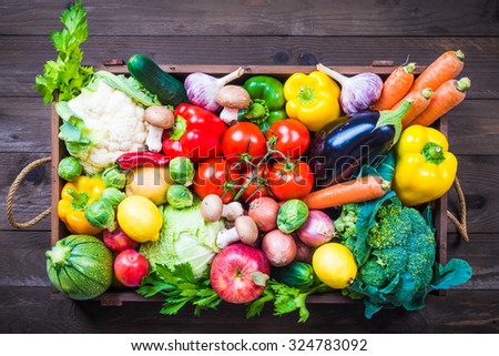 Vegetables and fruits in box on dark background copy space.