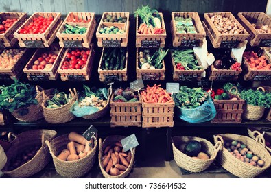 vegetables and fruits in wicker baskets on counter of greengrocery. on labels of product names in Catalan