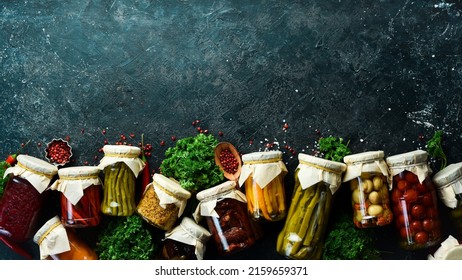 Vegetables in jars. Salting various vegetables in glass jars for long-term storage. On a stone background. Top view.