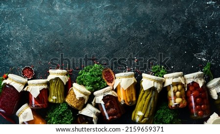 Vegetables in jars. Salting various vegetables in glass jars for long-term storage. On a stone background. Top view.