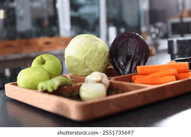 Vegetables in kitchen. Vegetables and fruits for cooking are on board. Cabbage, carrots and apples in kitchen. Cooking vegetable dish. - Powered by Shutterstock