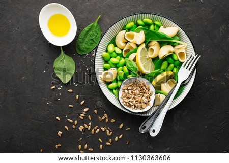 Vegetables, pasta, spinach, seeds bowl of salad. Vegetarian summer vegetable bowl with pasta and olive oil. Top View