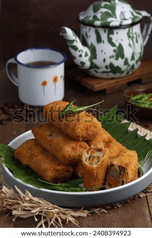 vegetables risoles or risol sayur or risoles sayur stuffed with veggies and enclosed in crepe-like wrappers and rolled into bread crumbs and fried. served on plate and chili. selected focus
