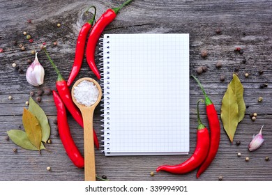 Vegetables and seasonings with open notebook for recipes on a wooden background - Shutterstock ID 339994901
