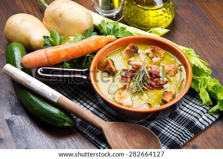 Vegetables soup with fresh vegetables all around the bowl