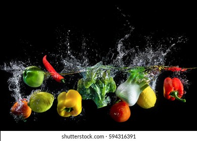 Vegetables Splash In Water On Black Background