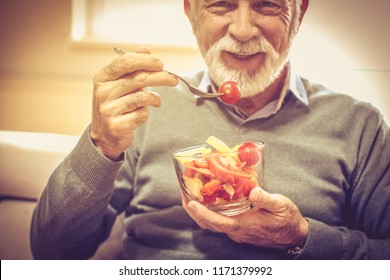 Vegetables Are Vitamin. Senior Man Eating Vegetable. Close Up. Focus Is On Hands.