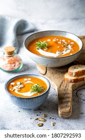 Vegetarian autumn pumpkin and carrot soup with cream, seeds and cilantro micro greens. Comfort food, fall and winter healthy slow food concept