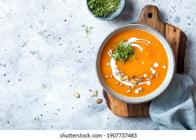 Vegetarian Autumn Pumpkin And Carrot Soup With Cream, Seeds And Cilantro Micro Greens. Comfort Food, Fall And Winter Healthy Slow Food Concept