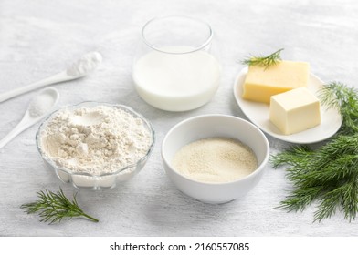 Vegetarian baking ingredients: flour, semolina, cheese, butter, yogurt, dill, salt and baking powder on a light gray background. Cooking delicious homemade food