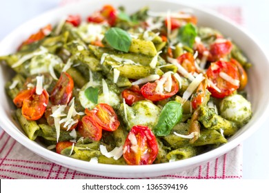 Vegetarian Basil Pesto Pasta With Roasted Cherry Tomatoes And Bocconcini, Mozzarella Close-Up Photo. Italian Food, Mediterranean Food, Veg Pasta Concept.