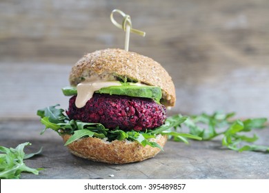 Vegetarian burger made of beetroot, broccoli and chickpeas with avocado and arugula - Shutterstock ID 395489857