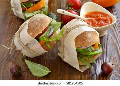 Vegetarian burger wrapped in paper and tied with twine with sauce
