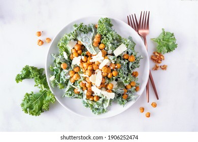 Vegetarian Caesar Salad With Chickpeas, Kale And A Yogurt Dressing. Top View Over A White Marble Background. Plant Based Food Concept.