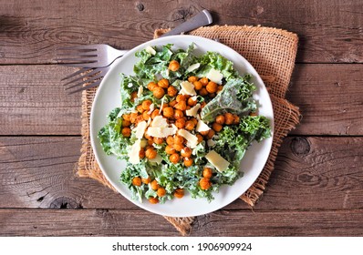 Vegetarian Caesar Salad With Chickpeas, Kale And A Yogurt Dressing. Overhead View Table Scene On A Rustic Wood Background. Plant Based Food Concept.