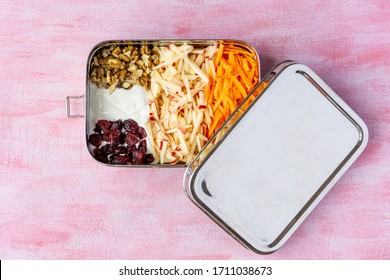 Vegetarian Carrot And Apple Salad In A Big Stainless Steel Food Container. Plastic Free Lunch Box Isolated On Pink Background. Zero Waste, Eco Friendly. 