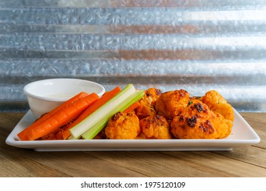 Vegetarian Cauliflower Buffalo Wings Served With Blue Cheese Dipping Sauce And Sliced Carrots And Celery