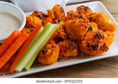 Vegetarian Cauliflower Buffalo Wings Served With Blue Cheese Dipping Sauce And Sliced Carrots And Celery