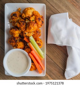 Vegetarian Cauliflower Buffalo Wings Served With Blue Cheese Dipping Sauce And Sliced Carrots And Celery