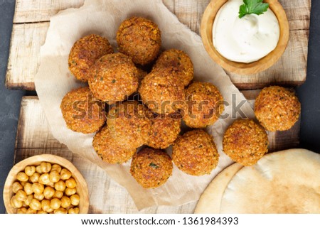 Vegetarian chickpeas falafel balls on wooden rustic board. Traditional arabian food. Dark background.