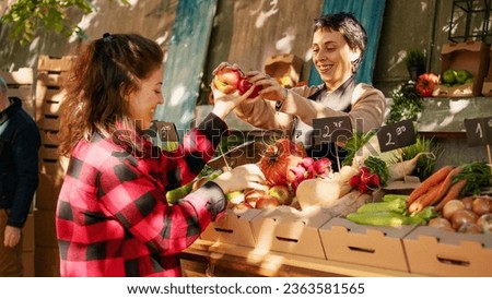 Vegetarian client choosing colorful apples and products, looking at organic produce on farmers market stall. Woman business owner selling fresh seasonal fruits and veggies at festival.
