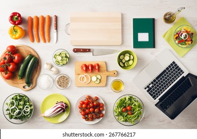 Vegetarian creative cooking at home with kitchen utensils, food ingredients and fresh vegetables on a wooden table, top view - Powered by Shutterstock