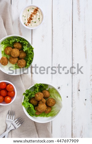 Foto Bild Falafel und Gemüse auf weißem Holzgrund. Draufsicht