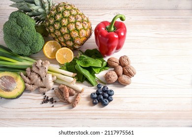 Vegetarian food with anti-inflammatory and antioxidant effect, arrangement of vegetables, nuts, fruits and spices on a light wooden background with copy space