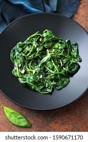vegetarian food cooked spinach in black dish  - Shutterstock ID 1590671170