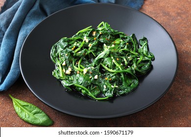 vegetarian food cooked spinach in black dish  - Shutterstock ID 1590671179