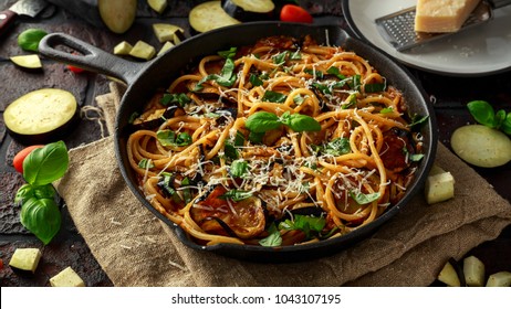 Vegetarian Italian Pasta Spaghetti alla Norma with eggplant, tomatoes, basil and parmesan cheese in rustic skillet pan. - Shutterstock ID 1043107195