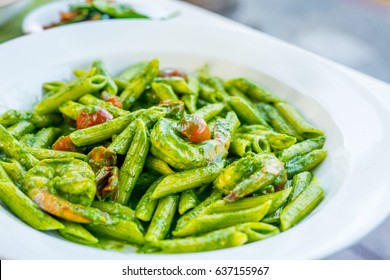 Vegetarian Italian penne pasta in pesto sauce with dried tomatoes in a restaurant - Powered by Shutterstock