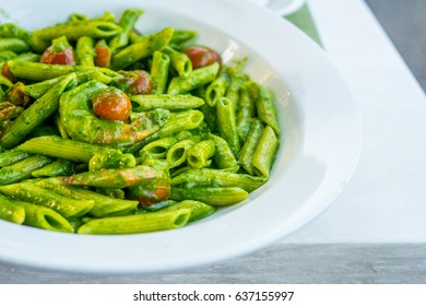 Vegetarian Italian penne pasta in pesto sauce with dried tomatoes in a restaurant - Powered by Shutterstock