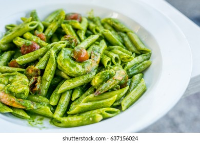 Vegetarian Italian penne pasta in pesto sauce with dried tomatoes in a restaurant - Powered by Shutterstock