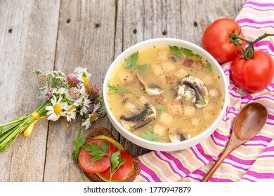 Vegetarian lunch with mushroom soup and fresh tomatoes on an old wooden background. - Powered by Shutterstock