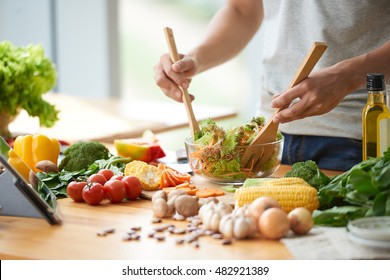 Vegetarian man mixing vegetable salad in bowl - Powered by Shutterstock