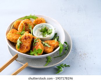 Vegetarian Nuggets with Vegan Dipping Sauce and rocket leaves on a light background with space for text, selective focus. Healthy Diet, Protein Vegetarian Meals concept, alternative meat products.