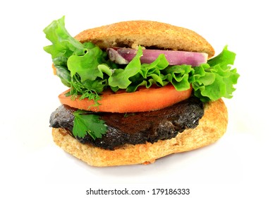 Vegetarian Organic Burger From Grilled Pre Marinated Portobello Mushroom, Slices Of: Whole Grain Ban, Tomato And Red Onion, Garnished With Leaf Of Lettuce And Sprig Of Dill Over White Background 