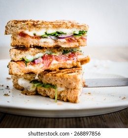 Vegetarian panini with tomatoes and mozzarella on rustic wooden table. Selective focus. - Shutterstock ID 268897856