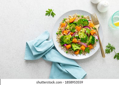 Gemütliche Quinoa und Broccoli warmer Salat mit gebackenem Butternut-Squash oder Kürbis, grüne Erbsen und frische rote Zwiebel, Draufsicht