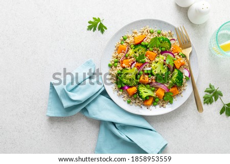 Vegetarian quinoa and broccoli warm salad with baked butternut squash or pumpkin, green peas and fresh red onion, top down view Сток-фото © 