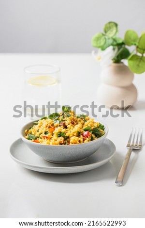Vegetarian salad  Tabule with  bulgur grain and vegetables seasoned with olive oil and lemon juice  served on the restaurant table with watter glass.Copy space