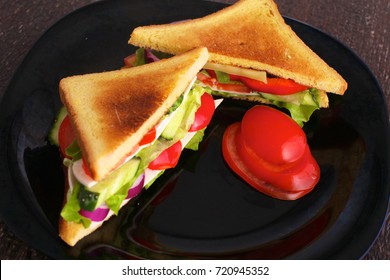 Vegetarian Sandwich With Tomato On A Black Plate