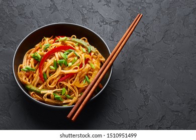 Vegetarian Schezwan Noodles or Vegetable Hakka Noodles or Chow Mein in black bowl at dark background. Indo-chinese cuisine hot dish with udon noodles, vegetables and chilli sauce. Copy space - Shutterstock ID 1510951499