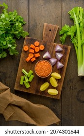 Vegetarian Set Of Healthy Vegetables On Wooden Board. Chopped Carrots, Potatoes, Red Onions, Lentsils, Parsley. Preparing Ingredients For Cooking Soup. Diced And Sliced Products. Vertical, Top View