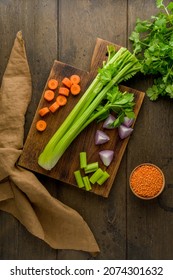 Vegetarian Set Of Raw Vegetables On Wooden Board. Chopped Carrots, Potatoes, Red Onions, Lentsils, Parsley. Preparing Ingredients For Vegan Cooking Soup. Diced And Sliced Products. Vertical, Top View