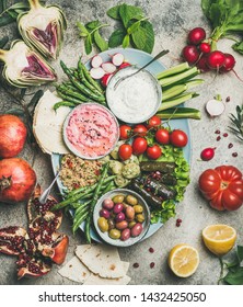 Vegetarian Snack Board. Flat-lay Of Beetroot Hummus, Yogurt Dip, Kinoa Salad, Olives, Beens, Vegetables And Fruit, Dolma, Flatbread Over Grey Concrete Background, Top View. Vegeratian Party Concept