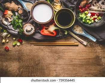 Vegetarian Stir Fry Ingredients With Coconut Milk, Soy Sauce And Chopsticks On Wooden Background, Top View, Border. Asian Food , Chinese Or Thai Cuisine Concept