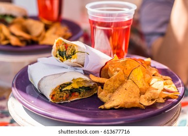 Vegetarian Vegan Burrito Wrap, Sweet Potato Fries Chips, And Raspberry Lemonade At A Street Food Market